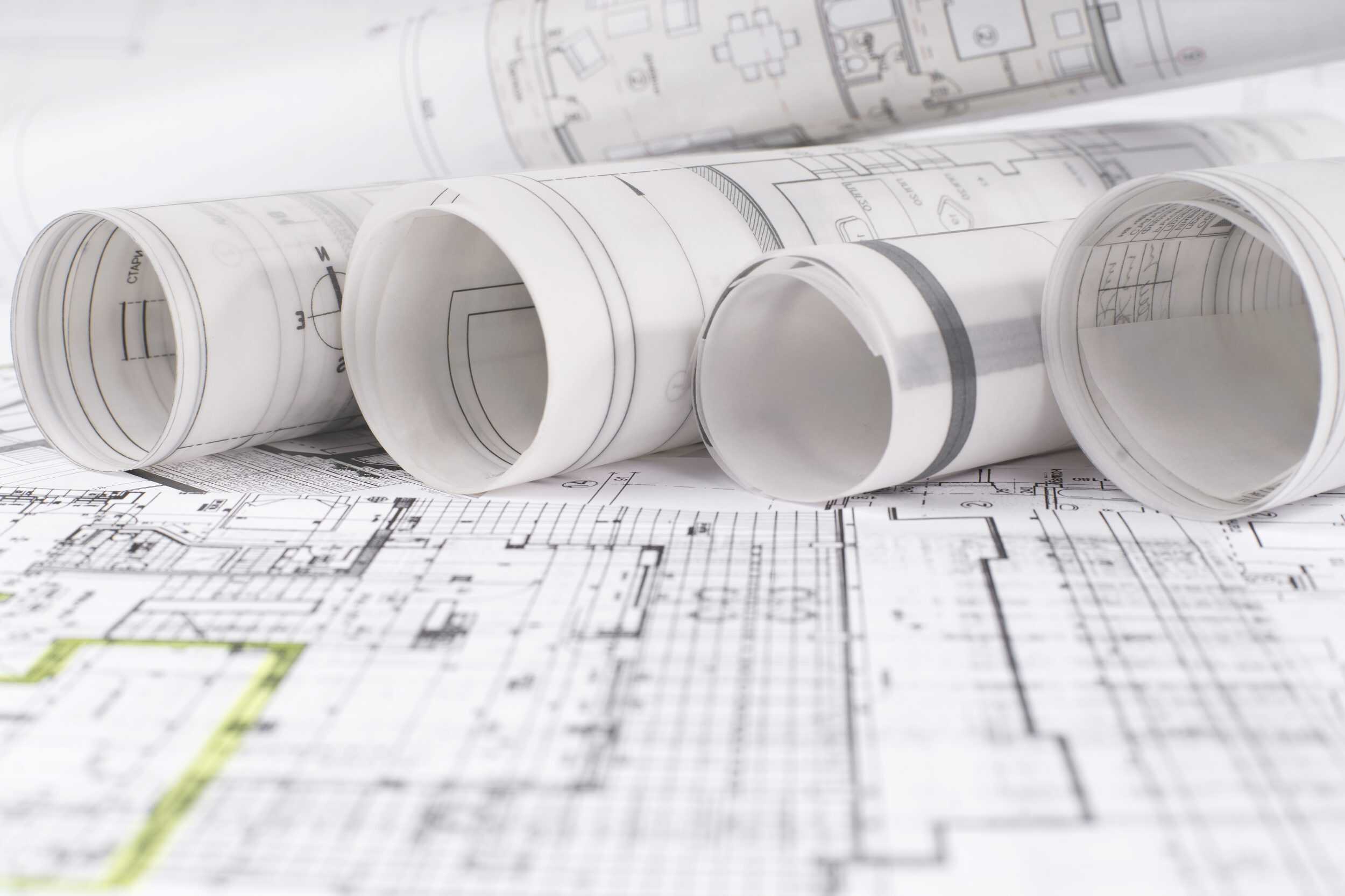 Architectural building plans and documentation spread on desk
