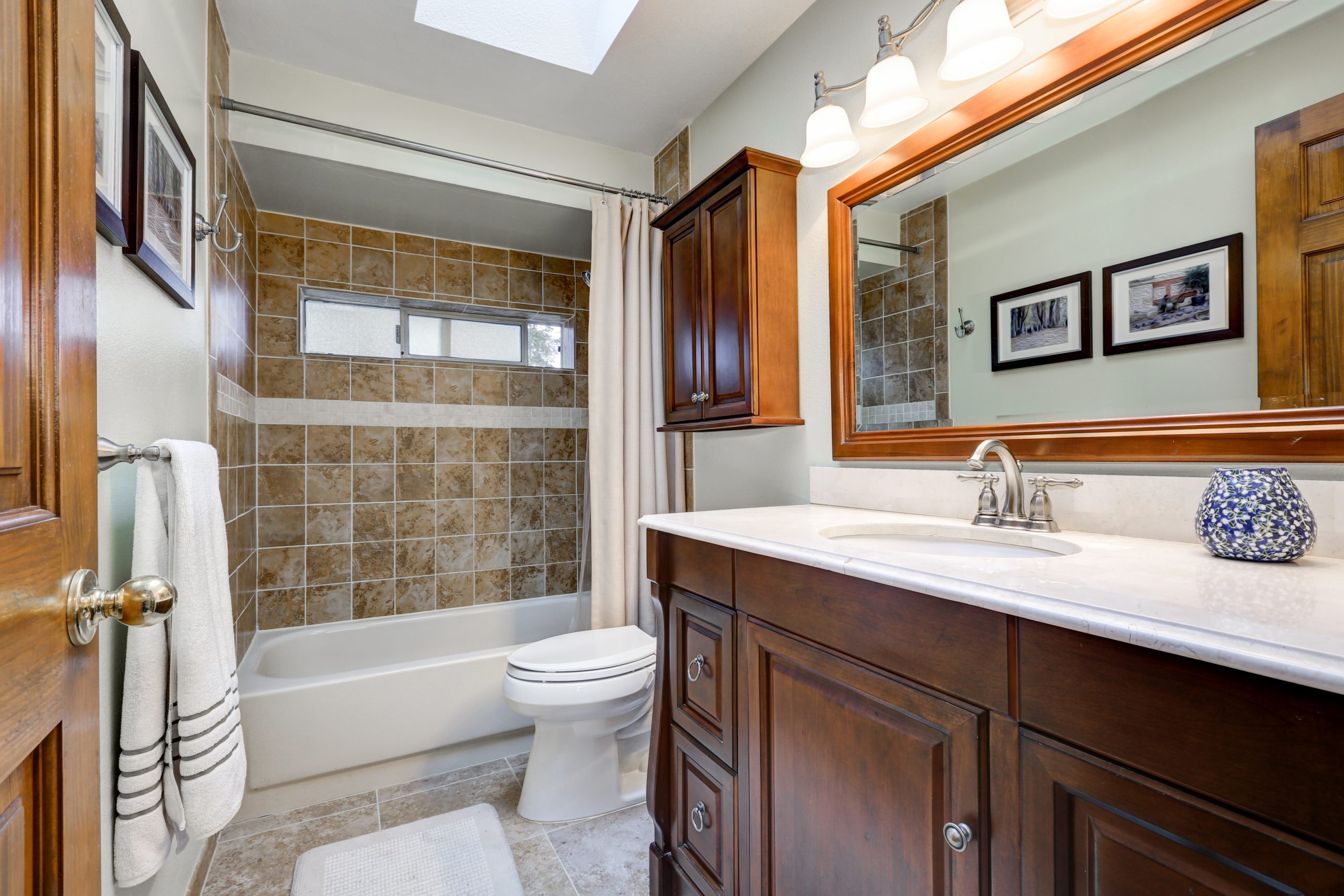 Traditional,bathroom,with,skylight,over,dark,brown,vanity,paired,with