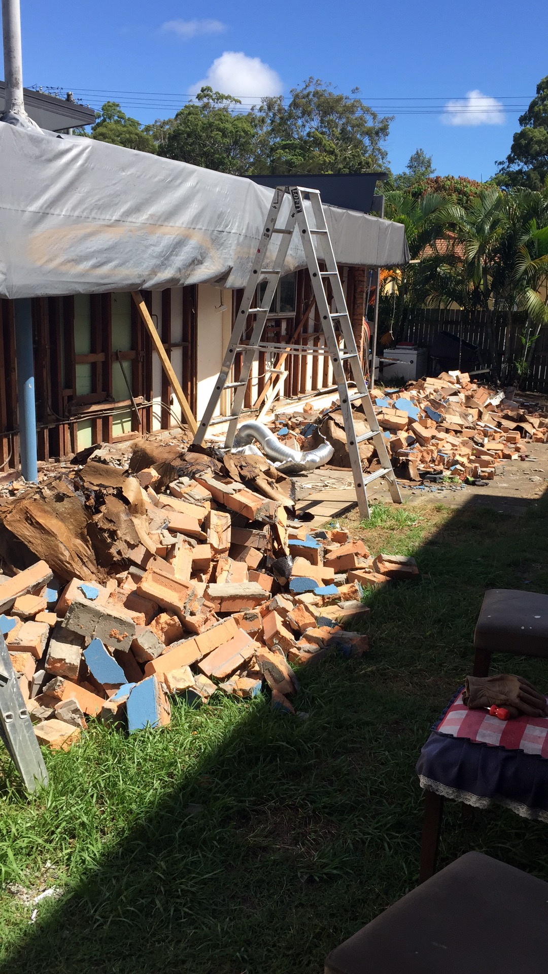 Demolished brick wall with exposed timber framing during structural demolition phase of Gold Coast home renovation
