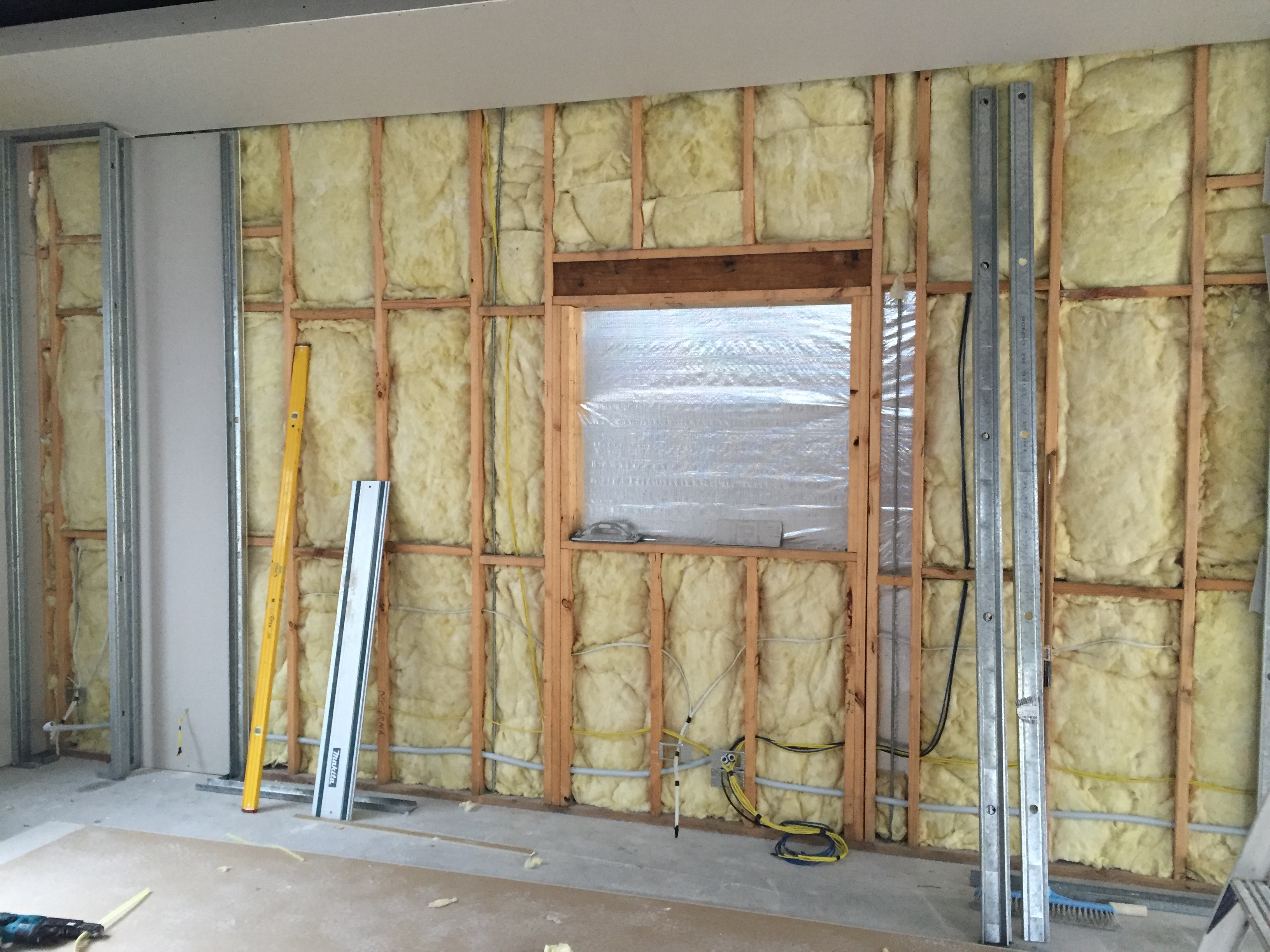 Glasswool insulation batts installed between timber studs with foil vapour barrier during Gold Coast renovation