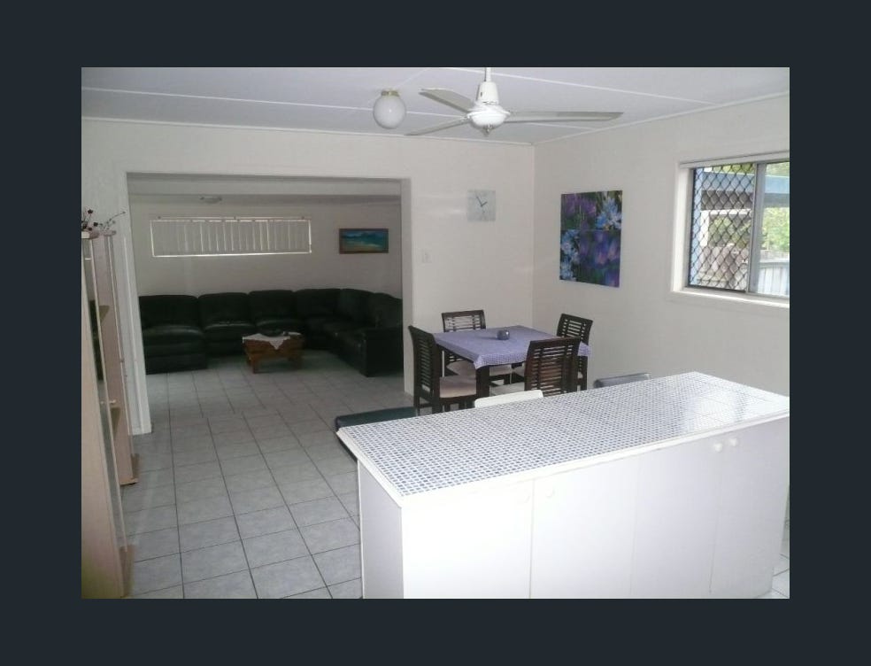 Dated kitchen with laminate timber-look cabinets, tiled benchtop and freestanding oven before Southport home renovation